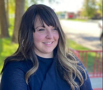 Portrait of Michelle Kiley, TripQuest advisor, smiling outdoors on a tree-lined path.